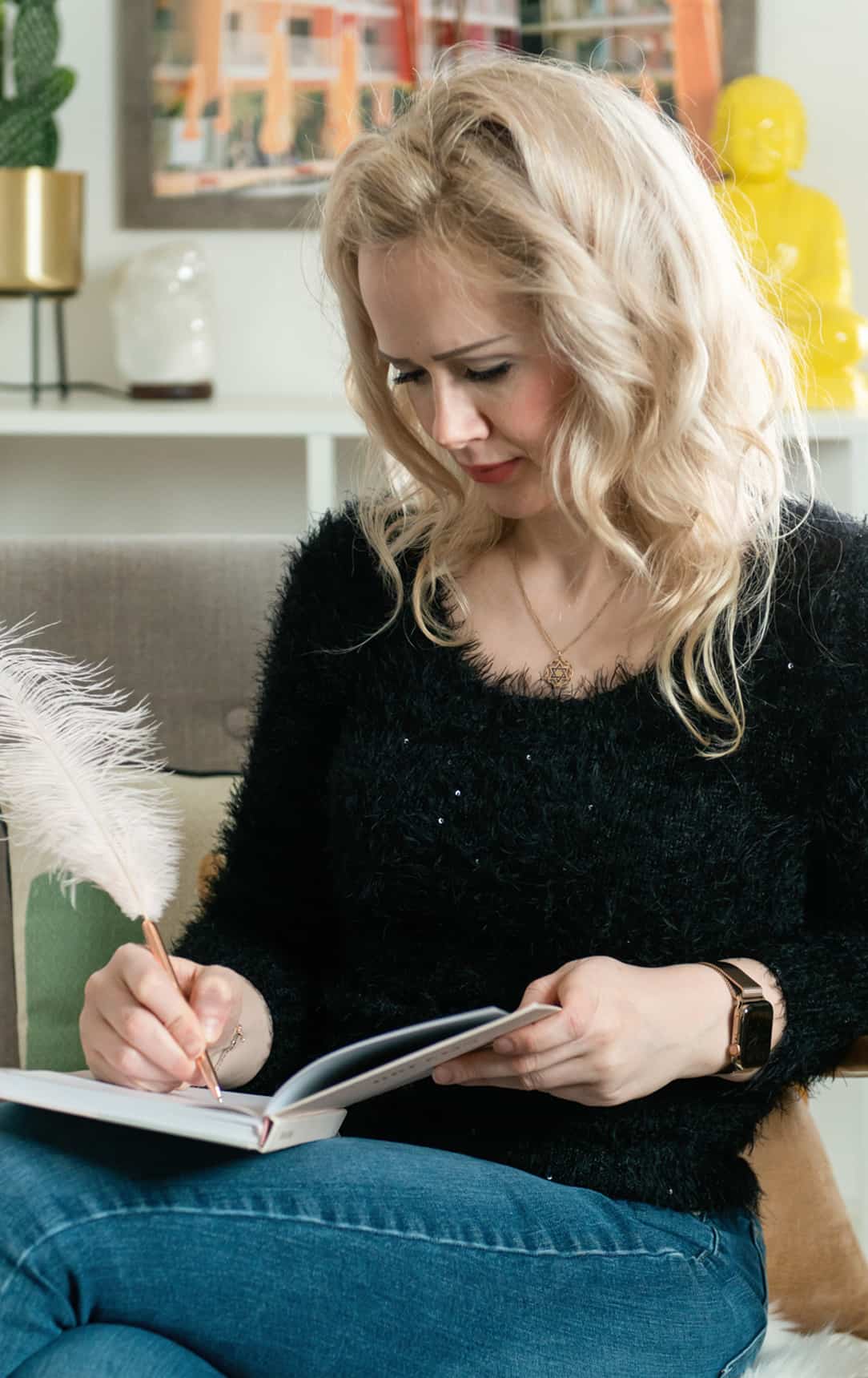 Sarah looking down whilst writing on a book in her lap