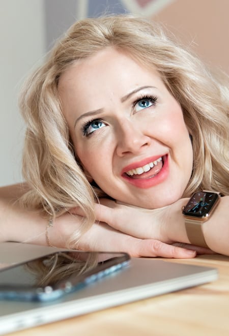 Sarah sitting at a desk with hands on a laptop