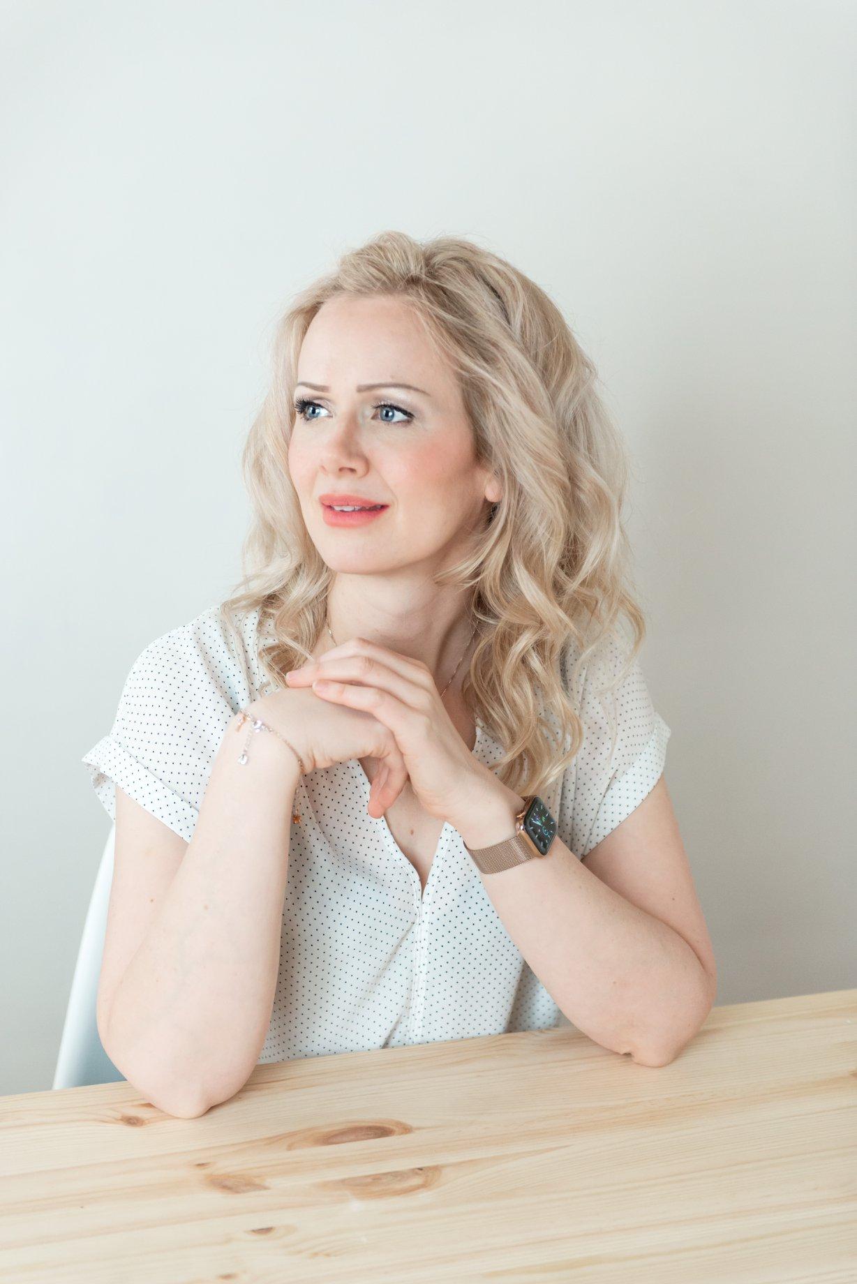 sarah sitting on top of a desk smiling at the camera