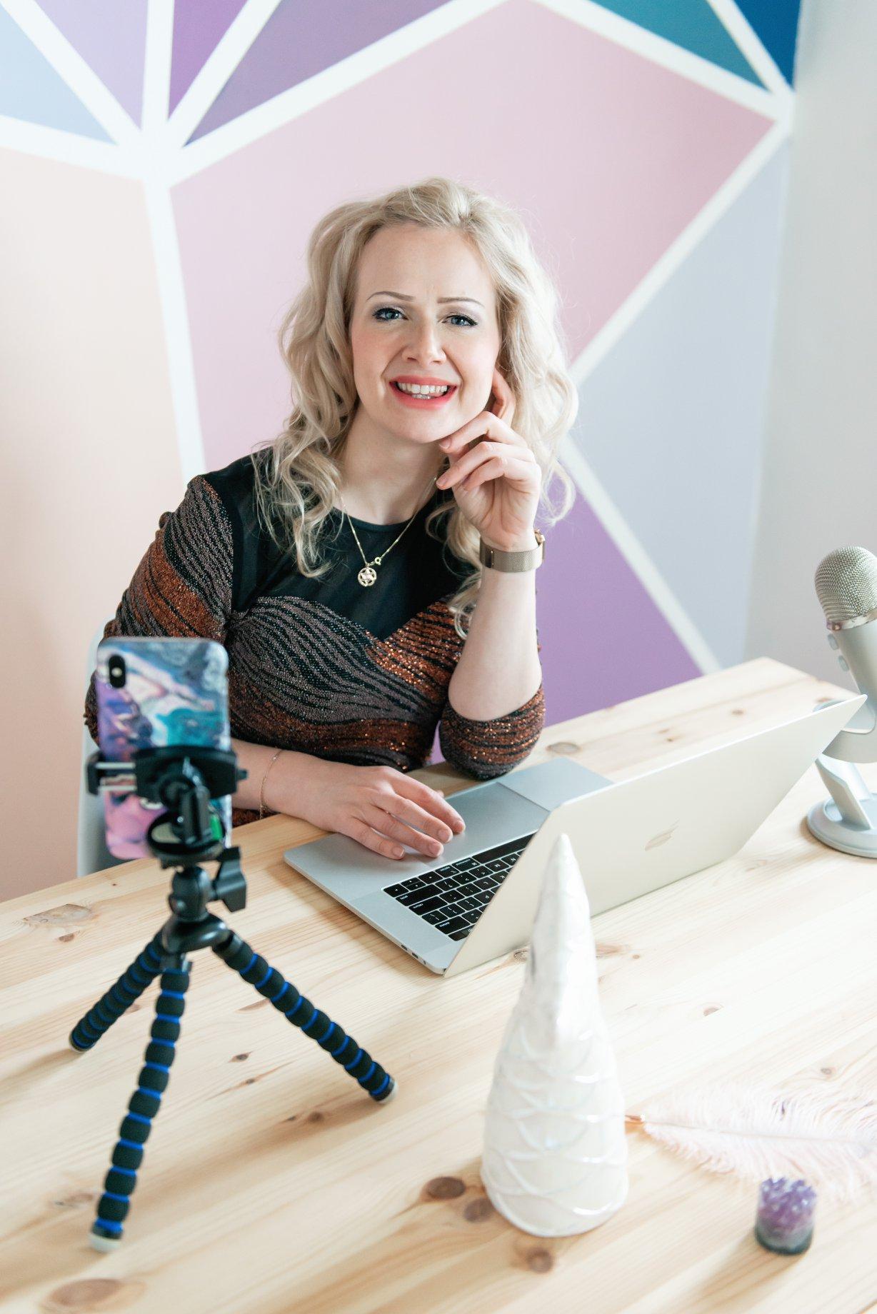 sarah sitting on top of a desk smiling at the camera