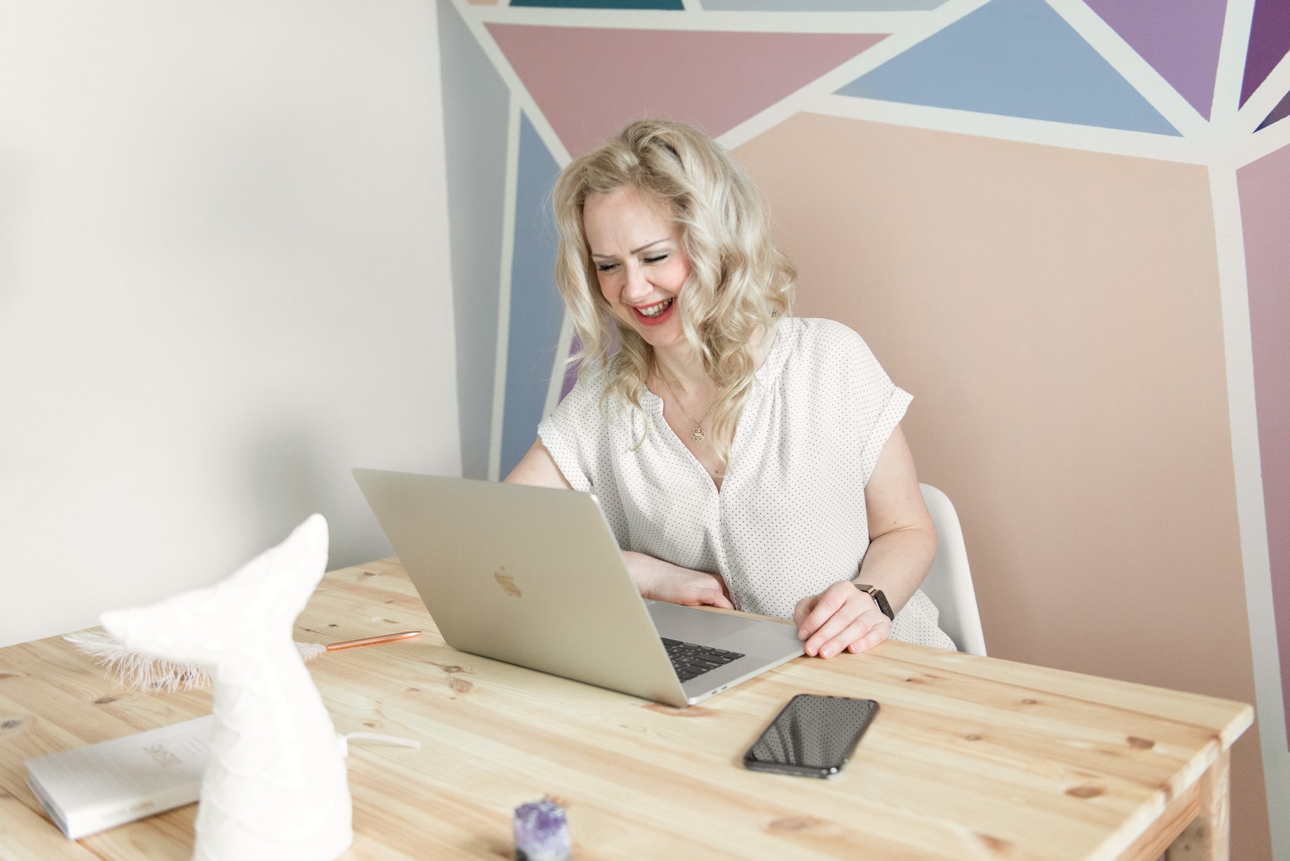 Sarah sitting at a desk with hands on a laptop