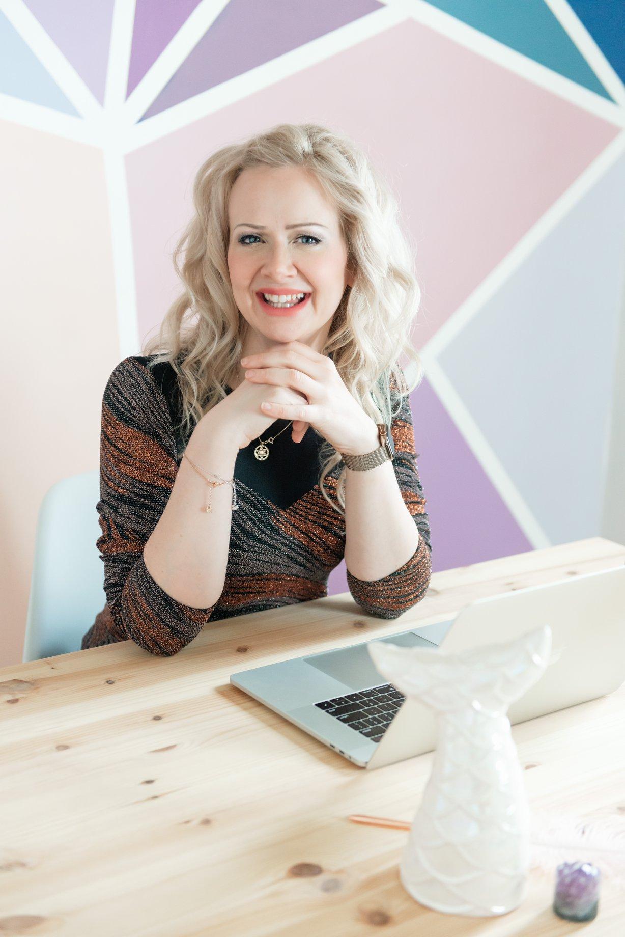 Sarah sitting at a desk with hands on a laptop